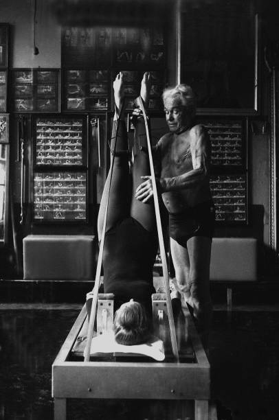 NEW YORK - OCTOBER 1961: Joe Pilates, Inventor, physical fitness guru and founder of the Pilates exercise method instructs a client on the Jackknife and works her through an exercise routine in his 8th Avenue studio on October 4, 1961 in New York City, New York. (Photo by I.C. Rapoport/Getty Images)